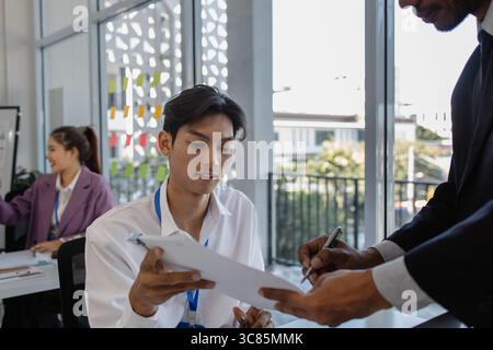 un gruppo di uomini d'affari si riunisce in una sala conferenze, gli imprenditori si incontrano per condividere le proprie conoscenze, il personale di marketing sta discutendo in fo Foto Stock