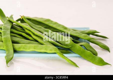 Fagioli verdi crudi disposti ordinatamente su un vassoio Foto Stock