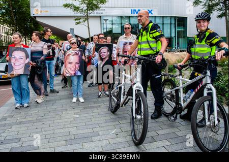 Gli agenti di polizia guidano e proteggono la marcia durante una manifestazione contro il femminicidio a Rotterdam. L'organizzazione femminista olandese "Dolle Mina" ha tenuto una marcia nazionale di protesta contro il femminicidio a Rotterdam. Questo è in risposta a due omicidi di donne in meno di una settimana. In entrambi i casi, il sospetto si è rivelato essere un (ex) partner della vittima. "Dolle Mina" richiede che il femminicidio sia riconosciuto come una "forma specifica e strutturale di violenza basata sul genere". Durante il discorso di uno dei genitori di una delle vittime, un uomo corse sul palco e cercò di interrompere l'evento. Foto Stock