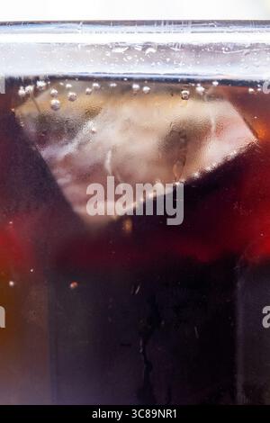Primo piano di cola frizzante con Ice Cube e bollicine Foto Stock