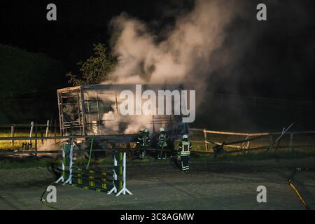 Großbrand zerstört Unterstand an Wuppertaler Reitsportzentrum - Feuerwehr kann Übergriff auf Pferdestall verhindern Große Flammen schlugen am Sonntagabend in den Nachthimmel als in einer Reitsportanlage am Aprather Weg ein ca. 30 qm Großer Unterstand mit Lagerflächen nello stand Vollbrand. Der Funkenflug drohte durch starken Wind auf einen angrenzenden Pferdestall überzugreifen. Dies konnte durch das rasche Eingreifen der Wuppertaler Feuerwehr glücklicherweise verhindert werden. MIT drei C-Rohren und einem B-Rohr führten die Feuerwehrleute einen massiven Löschangriff von zwei Seiten durch. Wupper Foto Stock