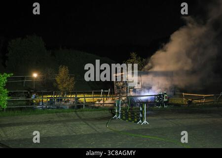 Großbrand zerstört Unterstand an Wuppertaler Reitsportzentrum - Feuerwehr kann Übergriff auf Pferdestall verhindern Große Flammen schlugen am Sonntagabend in den Nachthimmel als in einer Reitsportanlage am Aprather Weg ein ca. 30 qm Großer Unterstand mit Lagerflächen nello stand Vollbrand. Der Funkenflug drohte durch starken Wind auf einen angrenzenden Pferdestall überzugreifen. Dies konnte durch das rasche Eingreifen der Wuppertaler Feuerwehr glücklicherweise verhindert werden. MIT drei C-Rohren und einem B-Rohr führten die Feuerwehrleute einen massiven Löschangriff von zwei Seiten durch. Wupper Foto Stock