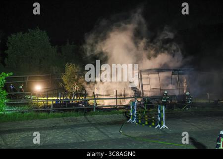 Großbrand zerstört Unterstand an Wuppertaler Reitsportzentrum - Feuerwehr kann Übergriff auf Pferdestall verhindern Große Flammen schlugen am Sonntagabend in den Nachthimmel als in einer Reitsportanlage am Aprather Weg ein ca. 30 qm Großer Unterstand mit Lagerflächen nello stand Vollbrand. Der Funkenflug drohte durch starken Wind auf einen angrenzenden Pferdestall überzugreifen. Dies konnte durch das rasche Eingreifen der Wuppertaler Feuerwehr glücklicherweise verhindert werden. MIT drei C-Rohren und einem B-Rohr führten die Feuerwehrleute einen massiven Löschangriff von zwei Seiten durch. Wupper Foto Stock