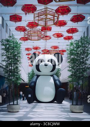 Una gigantesca scultura di panda si erge in primo piano nella nuova Chinatown del Dubai Mall, aggiungendo un giocoso punto di riferimento culturale al vibrante spazio. Foto Stock