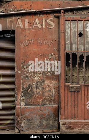 Febbraio 2011, Lione, Francia – edificio abbandonato con segnaletica francese sbiadita, vernice sbiadita e finestre rotte in una storica strada urbana. Foto Stock