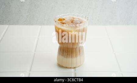 Caffè ghiacciato latte su sfondo bianco/versare caffè nella bevanda a base di latte freddo Foto Stock