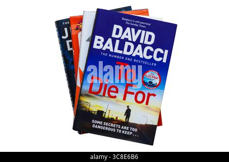 Una selezione di libri con To Die for di David Baldacci in cima isolati su sfondo bianco - alcuni segreti sono troppo pericolosi da mantenere Foto Stock