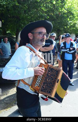 Musicista di strada, fisarmonicista Guerlesquin, Finistère, Bretagne Breizh Brittany, Francia, estate 2025 Foto Stock