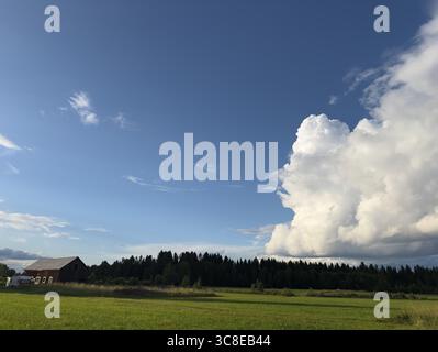 La splendida giornata estiva mostra un cielo vibrante sopra l'idilliaco paesaggio di campagna. Foto Stock