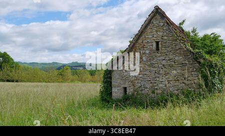 Vecchio fienile fatizzato e sovrastato costruito in pietra naturale tra Cornac e Saint-Céré Lot Occitanie nel sud della Francia in estate Foto Stock