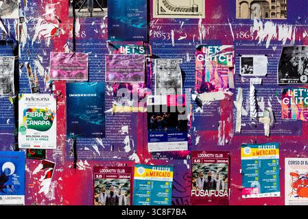 Parete coperta da poster e volantini per eventi a Bologna, Italia – Urban Street Scene Foto Stock