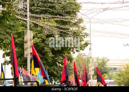 Memory Alley con bandiere ucraine e rosse-nere UPA in onore dei soldati caduti. Le bandiere sventolano sullo sfondo di alberi verdi e strade cittadine Foto Stock