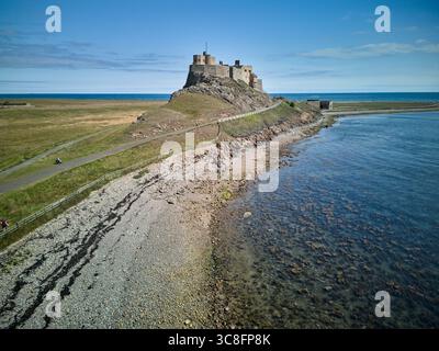 Vista aerea del castello di Lindisfarne sull'isola Santa, Northumberland, Inghilterra. La storica fortezza si trova in cima a una collina rocciosa che si affaccia sul Mare del Nord, a norma Foto Stock