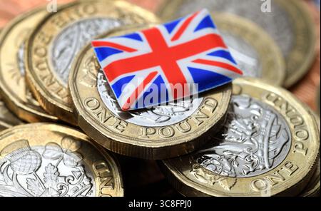 MONETE DA UNA STERLINA BRITANNICA CON BANDIERA UNION JACK RE L'ECONOMIA SALUTA PENSIONI DI RISPARMIO PENSIONE ETC UK Foto Stock