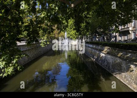 Les Quais de la Fontaine conduce ai Jardins de la Fontaine nel centro di Nimes in Francia Foto Stock