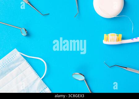 Igiene dentale e concetto di salute. Strumenti o strumenti dentali esploratori dentali, specchi dentali, spazzolino da denti, filo interdentale e maschera facciale procedurale Foto Stock