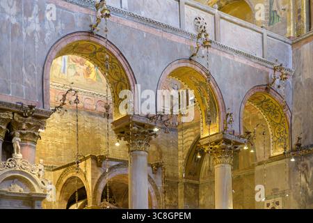 Colonne in marmo e archi dorati con capitelli ornati nella Basilica di San Marco, Venezia, Italia, che esemplificano l'ar italo-bizantino Foto Stock
