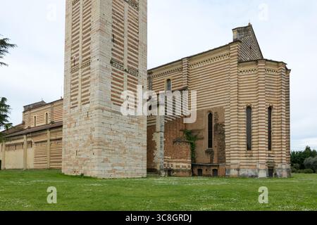 Vista laterale della Basilica di San Zeno a Verona, Italia, con muratura a strisce di mattoni e tufo e la base della campana romanica Foto Stock