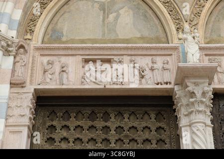 Dettaglio dell'architrave scolpita sopra il portale gotico di Santa Anastasia (Basilica di Santa Anastasia) a Verona, Italia, che mostra scene della vita Foto Stock