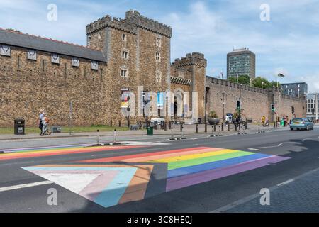 Progress Pride Flag sulla strada di fronte alla porta sud del Castello di Cardiff, Galles del Sud, Regno Unito, che celebra la diversità della comunità LGBTQ Foto Stock