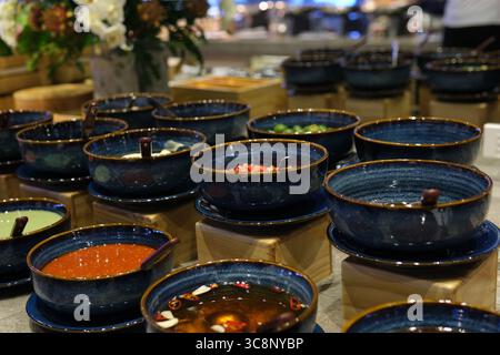 Tavola completa di buffet Cinese con Dim Sum al vapore, insalate, spuntini, Dim Sum fritto e al forno, tagliatelle, riso e zuppa, vivace buffet asiatico. Foto di alta qualità Foto Stock