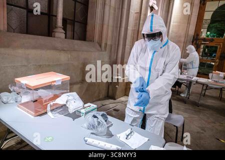 14 febbraio 2021, Barcellona, Catalogna, Spagna: Si vede un funzionario elettorale equipaggiarsi con le singole attrezzature di protezione anti-Covid..a causa della situazione della pandemia di Covid19, la Catalogna ha tenuto le elezioni regionali in fasce orarie consigliate per accedere ai seggi elettorali, fornendo l'ultima ora alle persone positive per Covid-19. (Immagine di credito: © immagini Paco Freire/SOPA tramite cavo ZUMA) Foto Stock