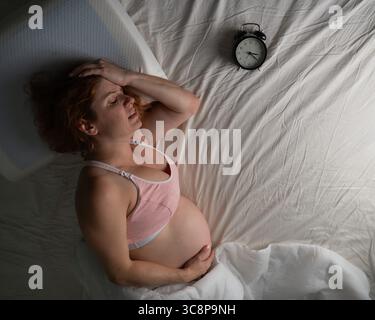 La donna incinta soffre di dolore di notte. Foto Stock