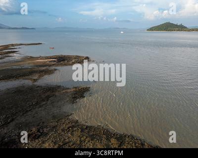Ripresa di barche a vela in legno ancorate vicino alla costa di un'isola tropicale, pittoresca località balneare con barche sull'acqua blu vicino alla spiaggia costiera. Paesaggio esotico. Foto Stock