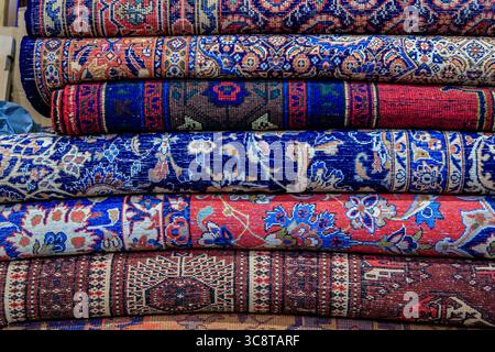Tappeti tradizionali turchi o tappeti hali con motivi intricati e colori vivaci esposti in un negozio in vendita nel Grand Bazaar di Istanbul, Turchia Foto Stock