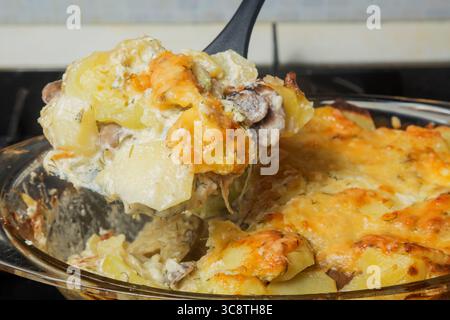 Patate smerlate fatte in casa con funghi e formaggio. Concentrati sul cucchiaio. Foto Stock