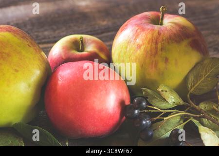 Mele verdi e rosse con cioccolato su fondo in legno. Foto Stock