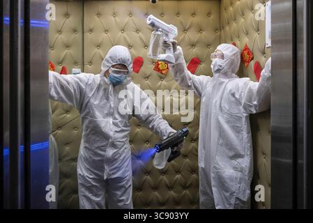 18 febbraio 2021, Hong Kong, Cina: I dipendenti che indossano DPI (Personal Protective Equipment) spray disinfettante in un ascensore presso la struttura Windsor Spa durante la sua riapertura..spa, palestre, cinema e altri tipi di attività hanno ripreso le attività il 18 febbraio dopo essere stati chiusi per più di due mesi, poiché il tasso di infezione da coronavirus Covid-19 si riduce significativamente. (Immagine di credito: © Miguel candela/SOPA Images via ZUMA Wire) Foto Stock