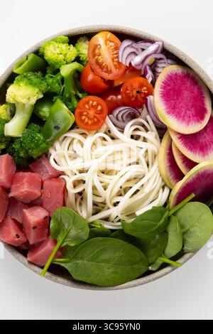 Vista dall'alto della ciotola degli spaghetti con tonno e verdure su una superficie leggera Foto Stock