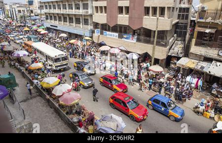 Accra, Ghana - 27 maggio 2017: Veduta di una vivace strada brulicante di venditori, automobili e pedoni sotto il caldo sole ghanese, che crea un vivace arazzo della vita urbana. Foto Stock