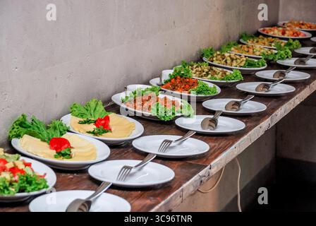 Tavolo a buffet con diversi antipasti su piatti con formaggi e insalate. Foto Stock