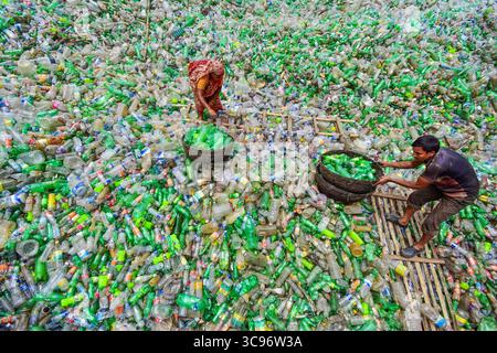 Bogura, Bangladesh - 26 luglio 2018: Vista di una vasta distesa di bottiglie di plastica scartate, dove i lavoratori si raccolgono e selezionano, creando uno scenario di preoccupazione ambientale. Foto Stock