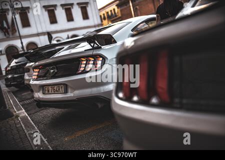 Roma, italia 5 agosto 2025: Vista posteriore della ford mustang bianca con luci di posizione posteriori visibili parcheggiate in una strada della città vicino ad altre auto simili Foto Stock