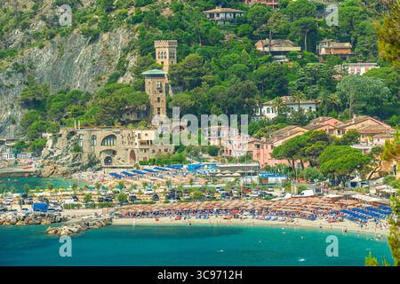 Gli amanti del mare e dei bagni di sole si rilassano sulla spiaggia nel villaggio costiero di Monterosso al Mare, cinque Terre in Italia Foto Stock