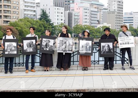 Hiroshima, Giappone. 5 agosto 2025. La gente tiene delle foto che promuovono un mondo pacifico vicino all'Atomic Bomb Dome, un sito patrimonio dell'umanità dell'UNESCO a Hiroshima, il giorno prima del 80° anniversario del bombardamento atomico statunitense della città. (Credit Image: © Rodrigo Reyes Marin/ZUMA Press Wire) SOLO PER USO EDITORIALE! Non per USO commerciale! Foto Stock