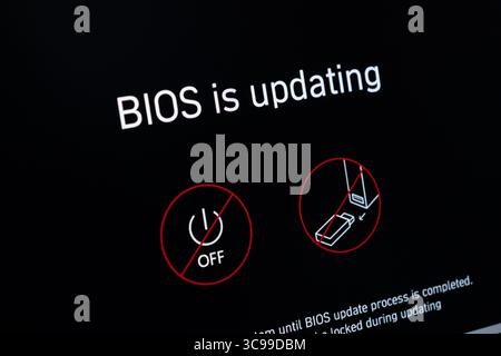 Poznan, Polonia - 29 luglio 2025: Primo piano dello schermo di un computer che visualizza il BIOS critico sta aggiornando testo e icone di sicurezza, che rappresentano la h essenziale Foto Stock