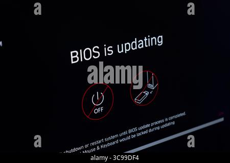Poznan, Polonia - 29 luglio 2025: Visualizzazione dettagliata dello schermo di un computer che mostra un processo di aggiornamento del BIOS in corso con avvisi cruciali per il sistema int Foto Stock