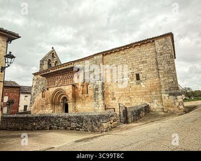 Storica chiesa romanica con portale decorato scolpito, campanile in pietra e robuste pareti in muratura. Foto Stock