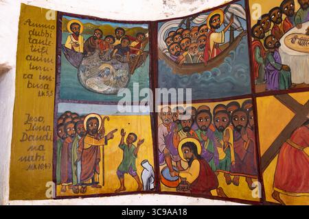 Kalacha, Kenya - 12 maggio 2022: Veduta di vivaci murales religiosi che raffigurano scene bibliche si dispiegano in colori ricchi, raccontando storie di fede e tradizione. Foto Stock