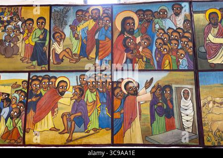 Kalacha, Kenya - 12 maggio 2022: Veduta di vivaci affreschi religiosi che raffigurano scene bibliche con toni terrosi profondi e aloni luminosi, catturando momenti di fede e comunità in una narrazione senza tempo. Foto Stock