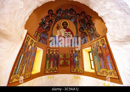 Kalacha, Kenya - 12 maggio 2022: Vista di vibranti opere d'arte religiose che adornano le pareti, raffiguranti santi e figure in un interno simile a una grotta, ricco di colori e narrazione spirituale. Foto Stock