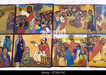 Kalacha, Kenya - 12 maggio 2022: Veduta di vivaci murales religiosi che raffigurano scene bibliche, figure rese in colori audaci contro sfondi caldi, che raccontano storie antiche attraverso una lente moderna. Foto Stock