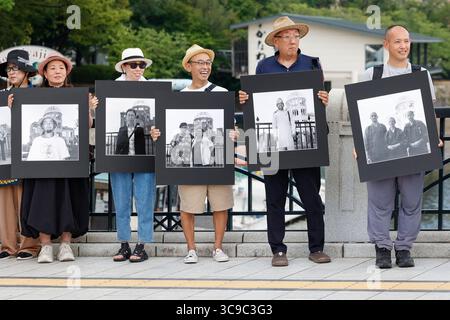 Hiroshima, Giappone. 5 agosto 2025. La gente tiene delle foto che promuovono un mondo pacifico vicino all'Atomic Bomb Dome, un sito patrimonio dell'umanità dell'UNESCO a Hiroshima, il giorno prima del 80° anniversario del bombardamento atomico statunitense della città. (Credit Image: © Rodrigo Reyes Marin/ZUMA Press Wire) SOLO PER USO EDITORIALE! Non per USO commerciale! Foto Stock