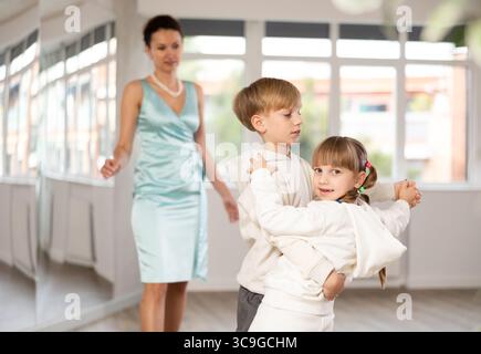 Ballerini Tween, ragazza e ragazzo che praticano il valzer in uno studio di danza Foto Stock
