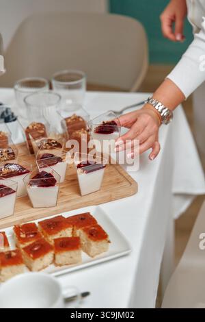 Deliziosi dessert esposti su un tavolo con budini cremosi e dolci dolci per una celebrazione speciale o un raduno Foto Stock