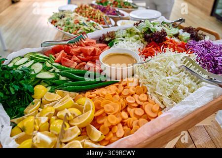 Piatto di verdure vivace con ingredienti freschi come verdure, pomodori, carote e condimenti per una delizia salutare Foto Stock